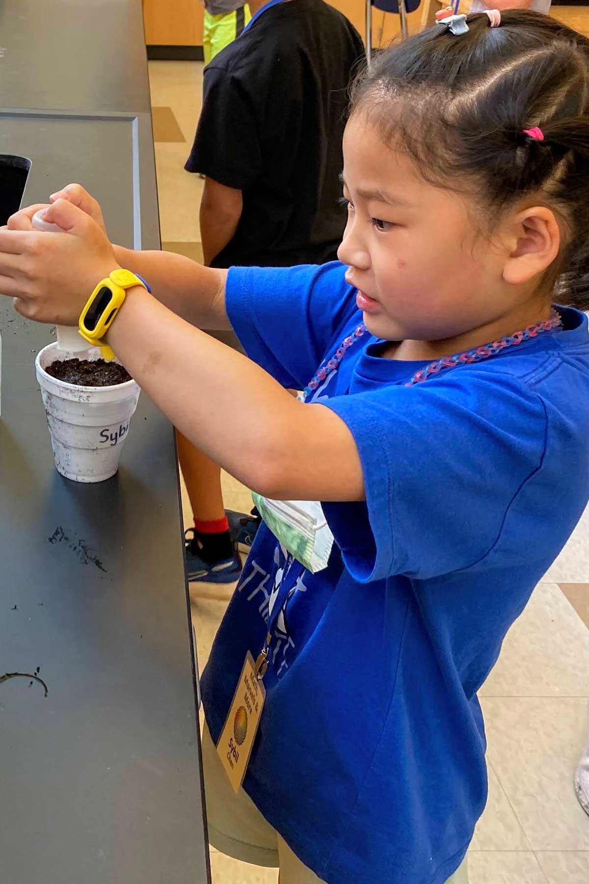 Young girl working with dirt in a cup